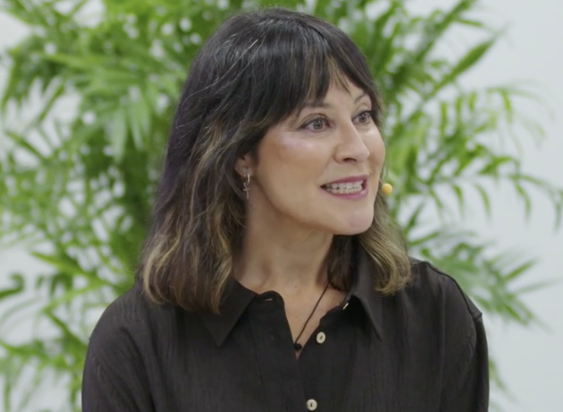 Ángela Medrano sonriendo, con un micrófono de solapa