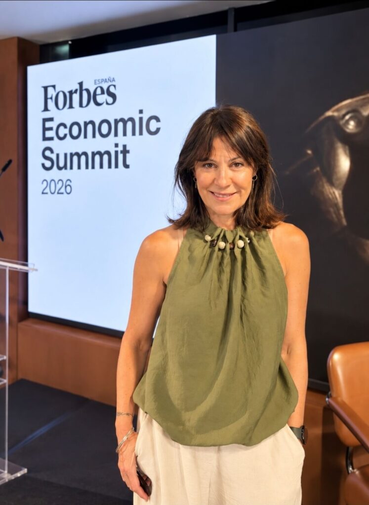 Ángela Medrano junto a la pantalla del Forbes España Economic Summit 2026, durante el evento